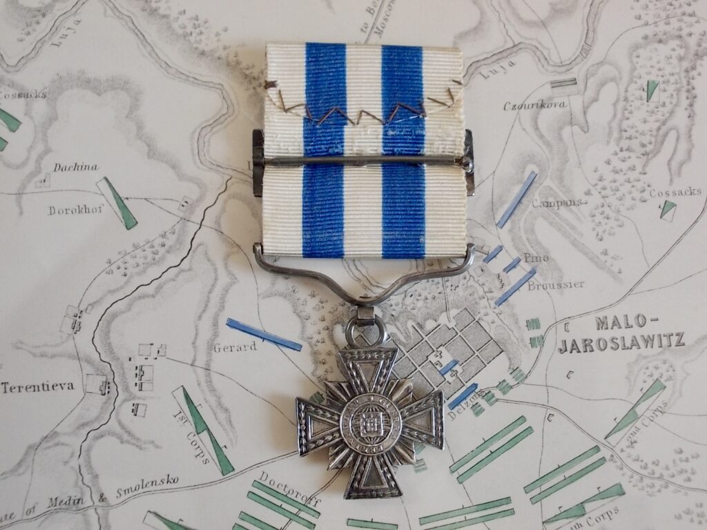 Croce della Guerra Peninsulare portoghese: croce patente d'argento su fondo raggiato, al centro lo scudo del Portogallo entro cerchio con legenda; nastro bianco e azzurro montato su fibbia.