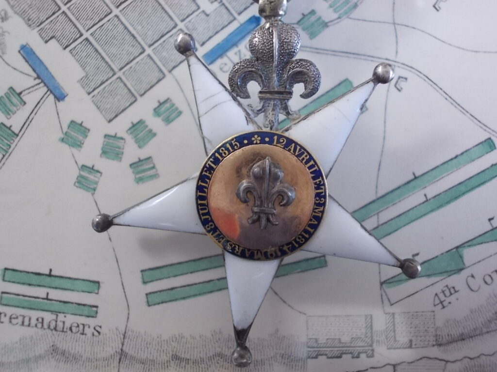 Fronte, ingrandimento del medaglione: «12 AVRIL 1814 – 3 MARS 1815 – 8 JUILLET 1815» su smalto azzurro, giglio al centro