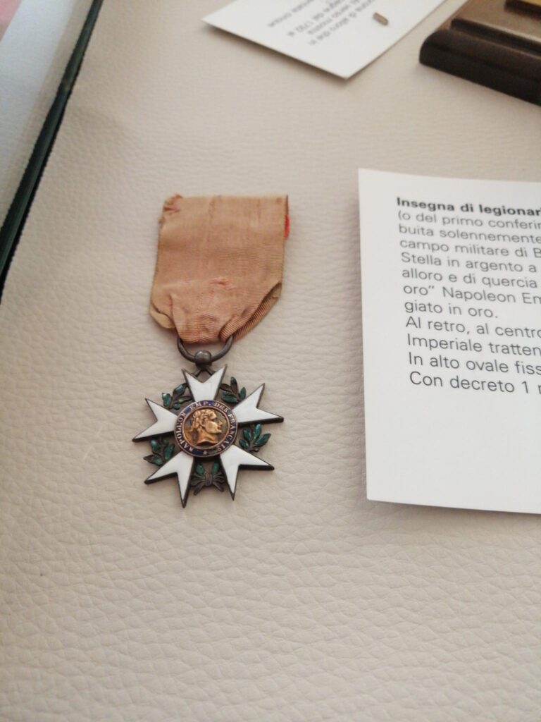 Insegna di legionario della Legion d'Onore, «Napoléon Emp. des Français», con il cartellino espositivo.