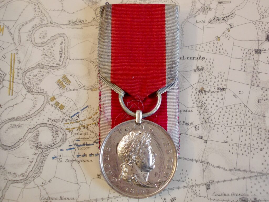 Medaglia di Waterloo hannoverana, 1815: al dritto il busto laureato del principe reggente, «GEORG PRINZ REGENT · 1815»; argento, nastro cremisi con bordi azzurri.