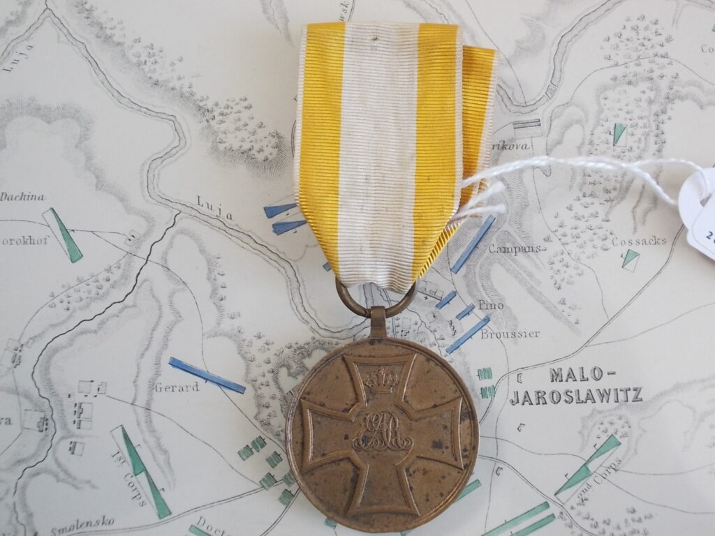 Medaglia d'onore della Legione Tedesca del Re (King's German Legion): al dritto croce patente con la cifra coronata «GR» di Giorgio III; bronzo, nastro giallo con riga bianca.